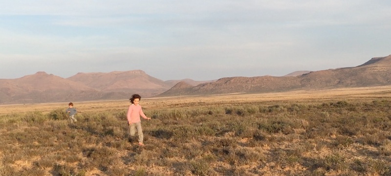Image of 2 young children racing through the quiet of the Karoo at Sneeuberg Nature Reserve.